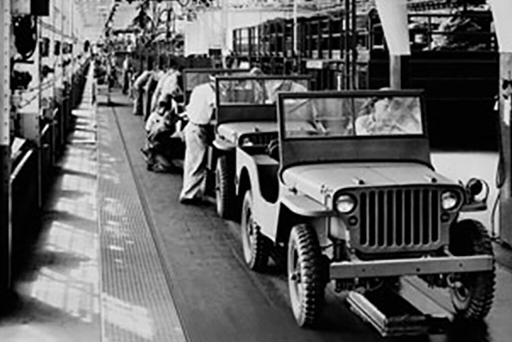 employees working on various cars on the Ford Motor Company assembly line