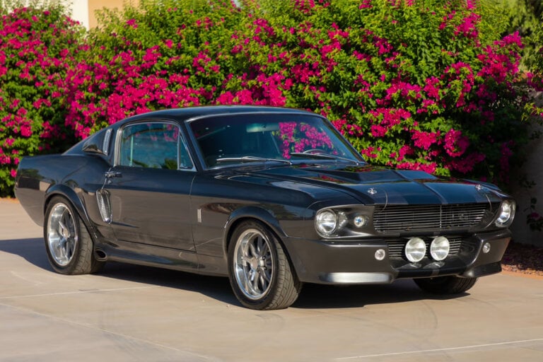 Grey Ford Mustang GT500 Eleanor parked infront of a bush with flowers