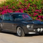 Grey Ford Mustang GT500 Eleanor parked infront of a bush with flowers