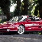 Red Toyota MR2 parked under some trees