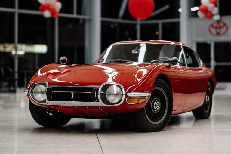 Red Toyota 2000GT displayed on the showroom floor of a Toyota dealership