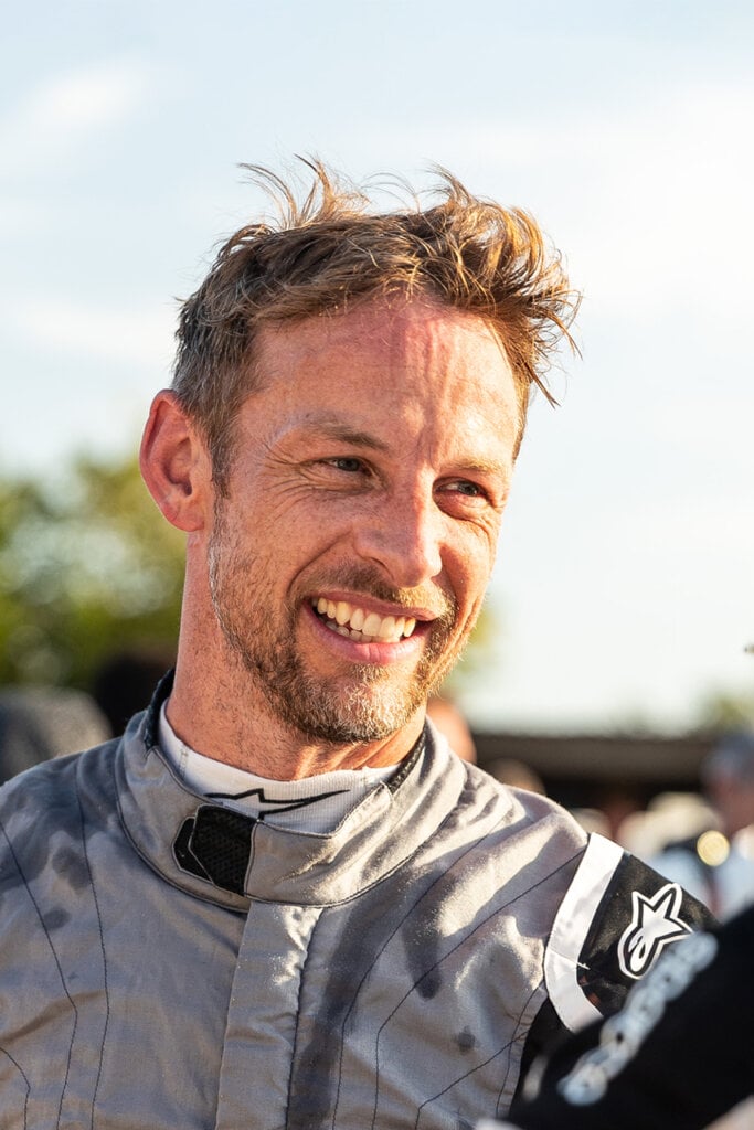Photo of a man in a grey racing suit smiling