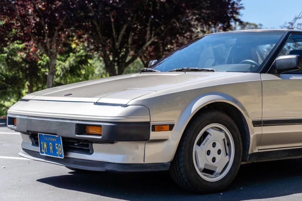 Silver Toyota MR2 preface lift parked in front of trees