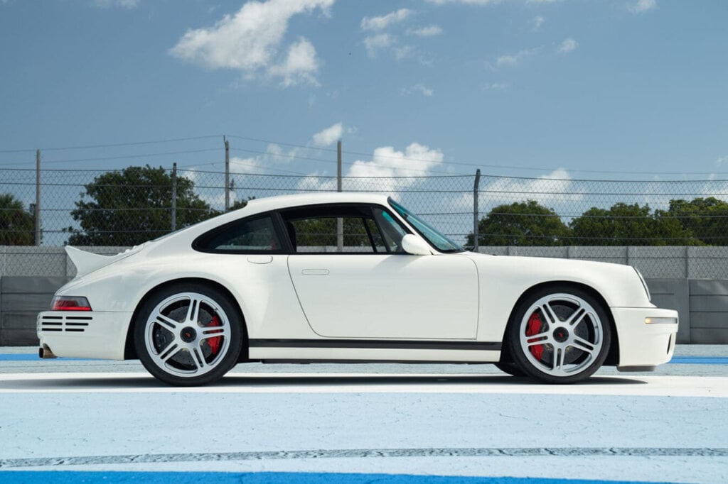 side profile shot of the White 2024 RUF SCR with a blue sky with some clouds in background