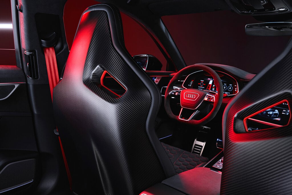 Interior shot of the Audi RS6 with carbon fiber bucket seats, a red glow shining through the window