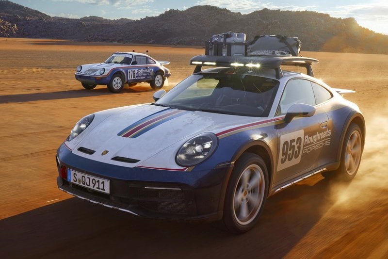Two variations of the Porsche 911 Dakar edition vehicles driving in the salt flats