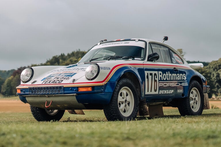 white and blue Porsche 911 953 rally race car parked on the grass