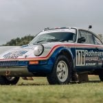 white and blue Porsche 911 953 rally race car parked on the grass