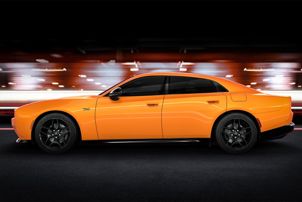 Side profile of orange Charger R/T on distorted background