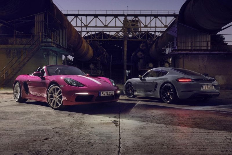 Two Porsche vehicles parked next to one another under steel structuring