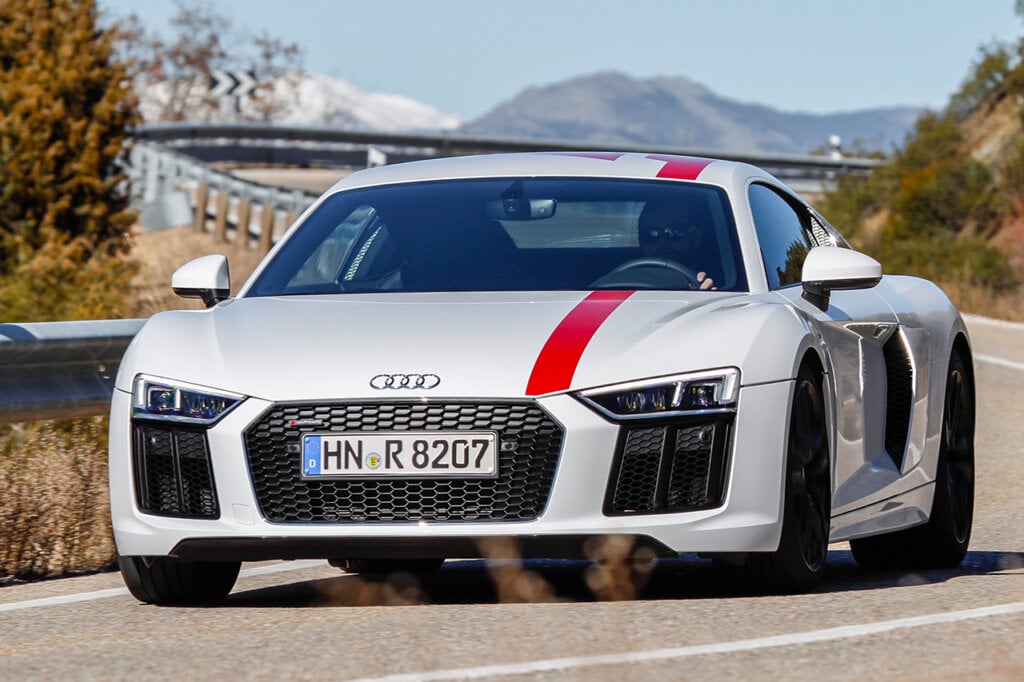 white r8 with red stripe going over hood and roof with a man driving 