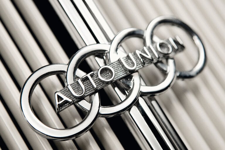 Former Audi logo that says auto union through the center with white pillars behind it