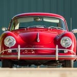 Red Porsche 356 parked in front of a green striped wall