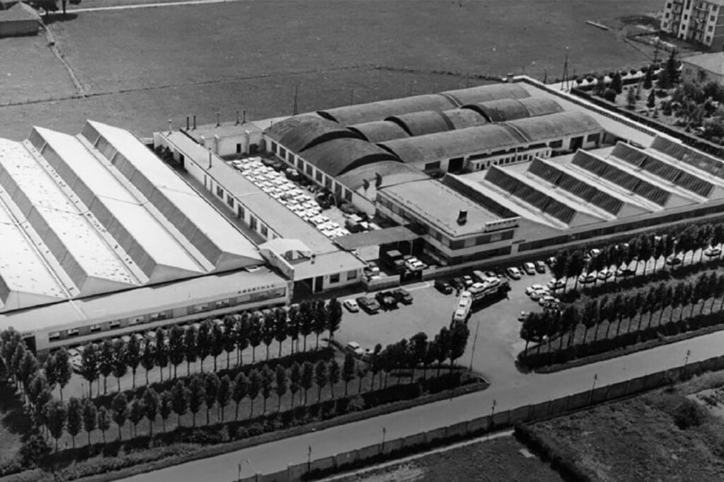 black and white photo of aerial view of warehouse with cars and trees in the front