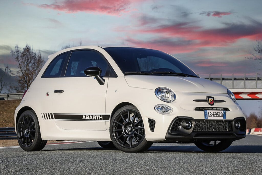 White Fiat Abarth 695 on asphalt pictured with a sunset sky