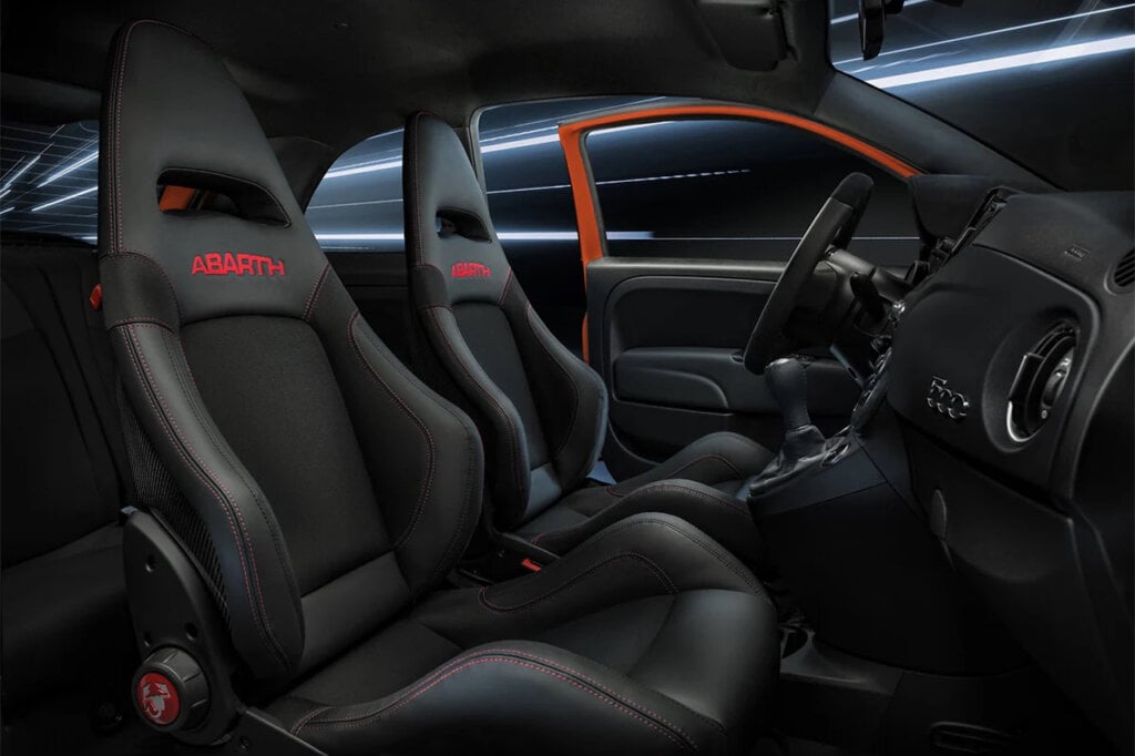 Black interior seats with red stitching saying Abarth