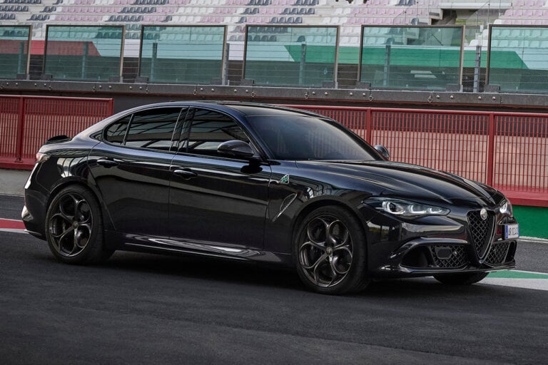 Black Alfa Romeo Giuilia Quadrifoglio Super Sport parked on a racetrack with empty stands behind it