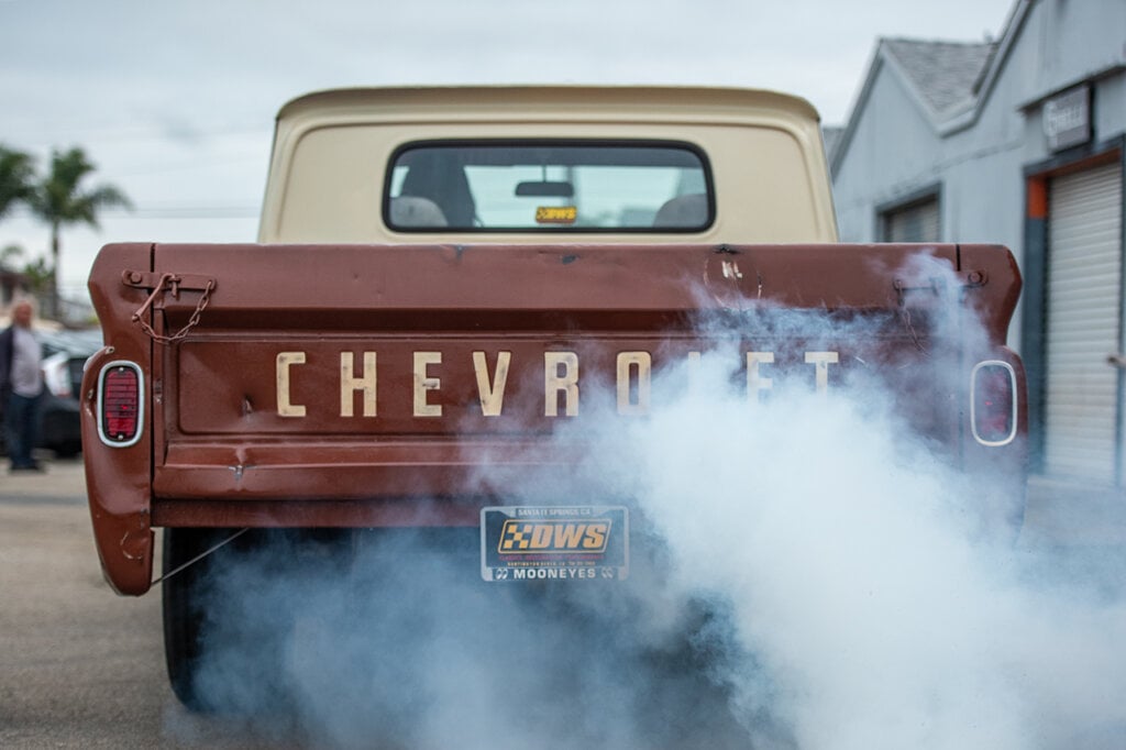 Brown C10 with white hardtop with smoke coming out of the back of the truck