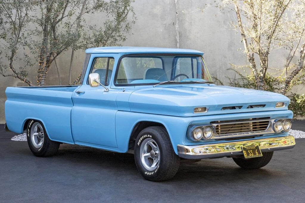 Light blue 1960 Chevy C10 parked with trees in background