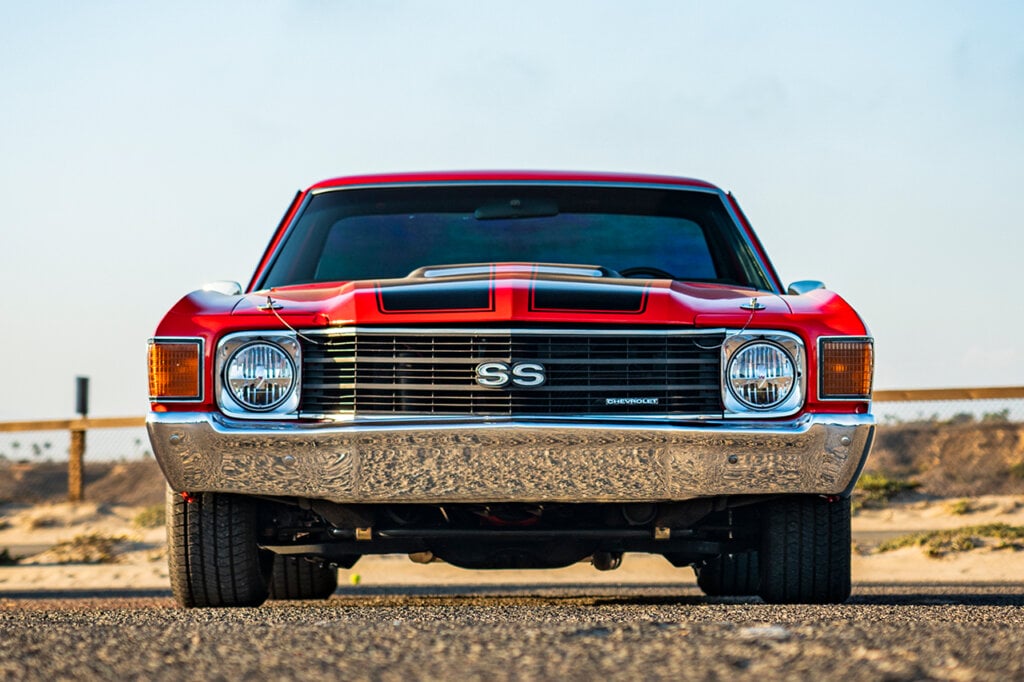 Red with black racing stripes of an El Camino with circular headlights
