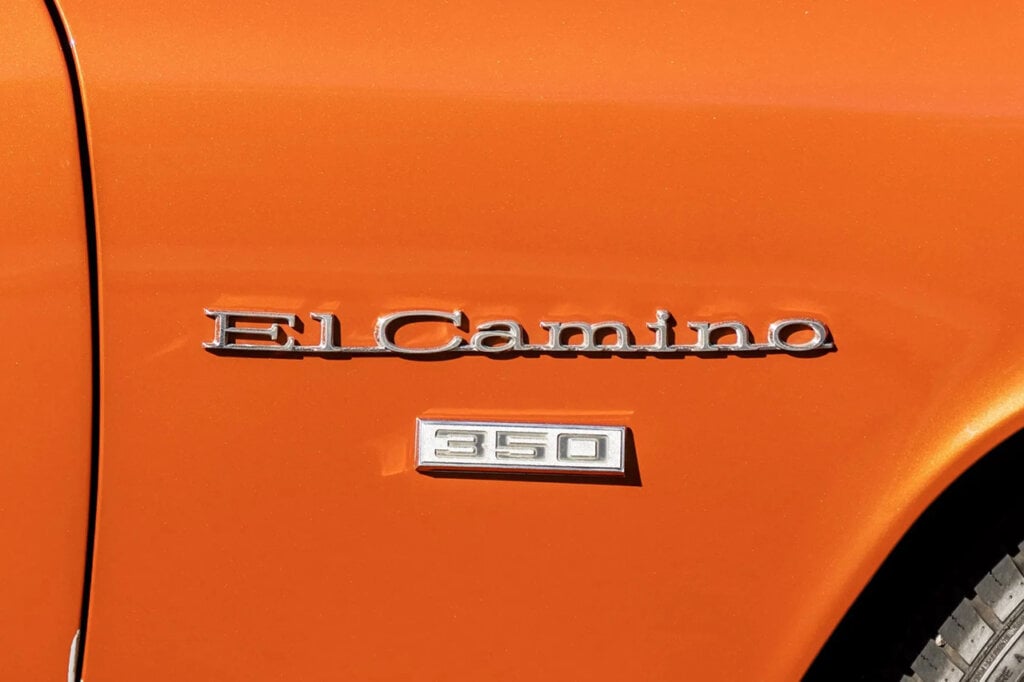 "El Camino" badge above  a small white one that says 350, both on an orange car door frame