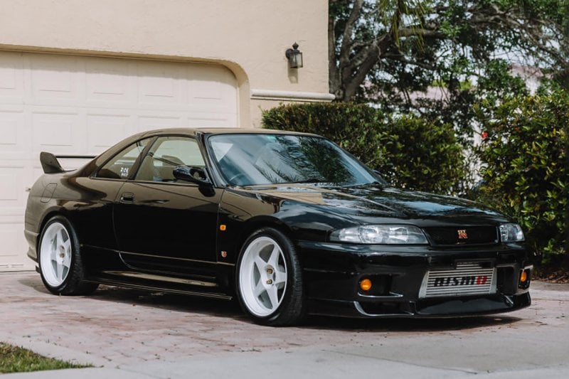 Black GTR R33 in front of a house