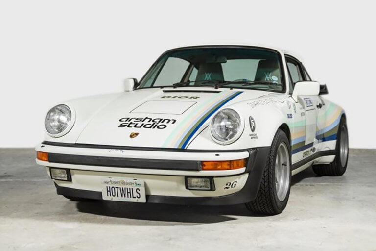 white porsche 930A 911 parked in a garage with a white wall behind it