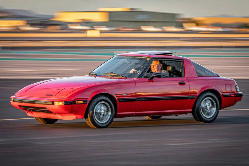 Red Savanna Rx7 FB with a man driving fast on a roadway