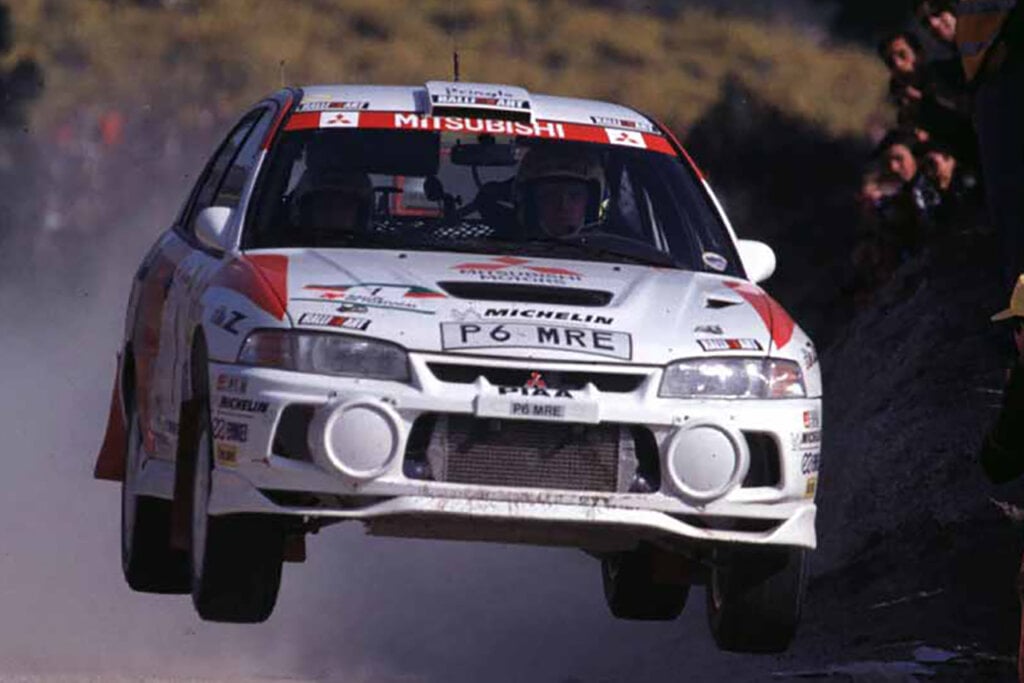 White Mitsubishi EVO VI with red accents flying through the air
