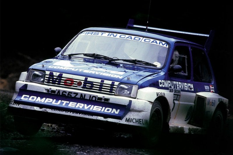 Blue MG Metro 6R4 driving fast with dark background